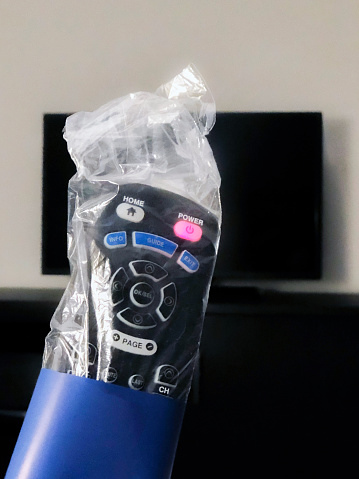 A TV remote wrapped in plastic.
